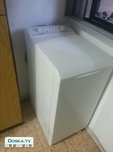 Стиральная машина фирмы "Spectra" с верхней загрузкой, в рабочем состоянии.