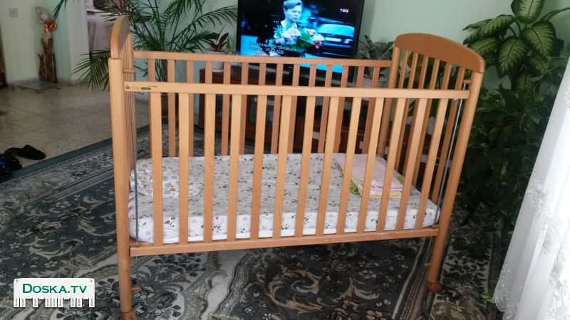 Детская кроватка светлого дерева.В хорошем состоянии с матрасом.