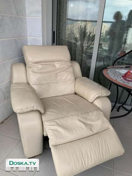 Удобное кожаное кресло, молочно-кремового цвета. С регулировкой подголовника и регулируемой